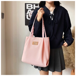Detailed close-up of pink corduroy tote bag featuring a leather Cowboy Bag logo patch