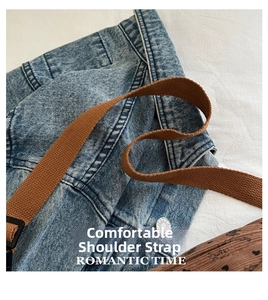 Detail van blauwe gewassen denim met gegraveerde knopen en bruine geweven schouderband