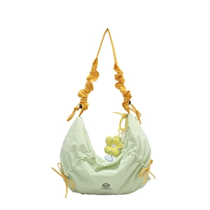 Green crescent hobo bag with yellow ruched strap and flower charm in nylon fabric