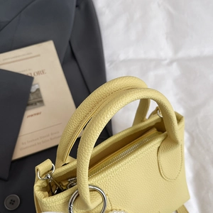 Litchi pattern leather bucket bag in pale yellow with silver metal ring handles