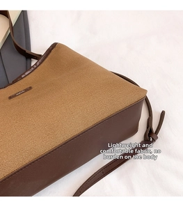 Detail of khaki canvas tote bag with brown leather trim and fashion nameplate