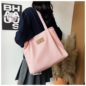 Detailed view of pink canvas tote bag with Cowboy bag leather patch and woven texture