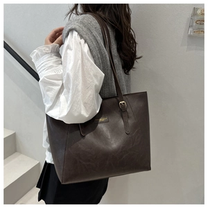 Detail of vintage brown tote bag with adjustable strap and gold brand lettering