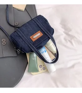 Detailed interior view of a blue denim crossbody bag showing its spacious capacity for storage