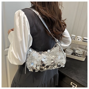 Close-up of sparkling silver sequin detail and crescent shape on shoulder bag