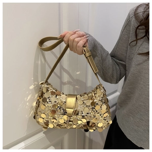 Détail des paillettes dorées scintillantes et de la bandoulière en cuir de ce sac chic
