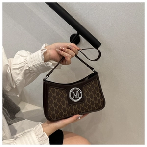 Detail of vintage brown shoulder bag featuring leather trim and M-pattern monogram texture