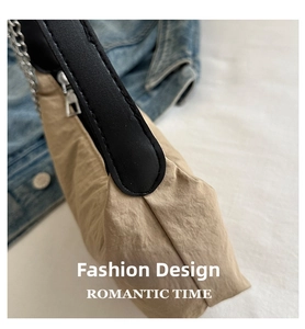 Detail of khaki pleated nylon texture with black leather strap and silver chain hardware
