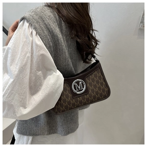 Retro brown underarm bag with M-letter pattern and silver metal buckle on a shoulder
