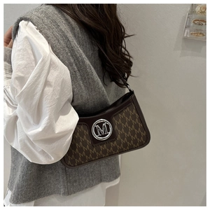 Detail of vintage brown monogram shoulder bag with metallic M buckle and curved structure