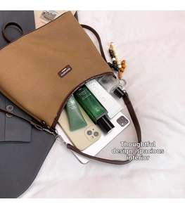 Spacious interior of brown canvas handbag showing tablet, cosmetics and daily essentials