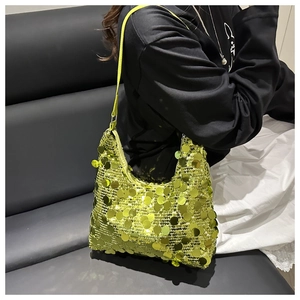 Détail du sac hobo à paillettes vert fluo porté par un mannequin sur fond en cuir