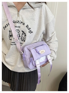 Side view of a purple waterproof nylon crossbody bag with adjustable strap and buckles