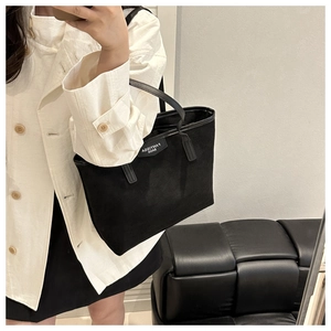 Close-up of a black tote bag with FANYISSA label shown in a lifestyle mirror selfie