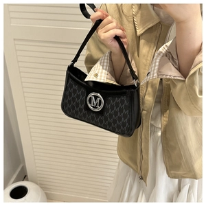 Close-up of black shoulder bag featuring monogram M print and silver logo hardware