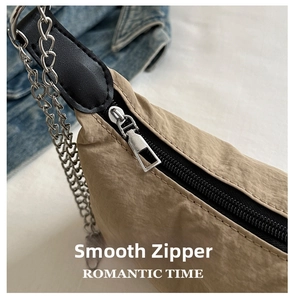 Detail of khaki nylon bag with metallic zipper and reinforced black leather joint