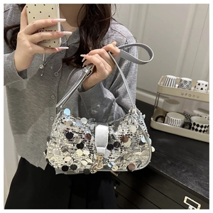 Détail du sac demi-lune à paillettes argentées avec boucle métallique et bandoulière