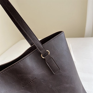 Dark brown leather tote bag with fine straps and gold hardware for office commuting