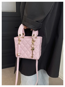 Detail of pink quilted handbag with diamond stitching and golden key charm decoration