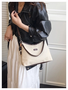 Gros plan du sac seau en toile avec finitions en cuir et détail de perles en bois