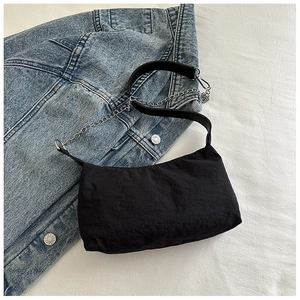 Close-up of black pleated nylon bag with stylish silver metal chain and shoulder strap