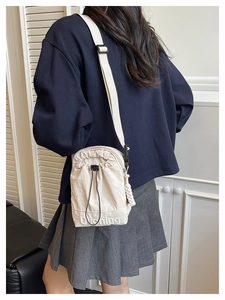 Détail du sac seau en toile blanc crème avec cordon et broderie Duoning élégante