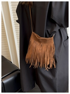Detail of bohemian brown suede crossbody bag with fine fringe and slender strap