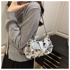 Close-up of silver sequin crossbody bag with metallic buckle and slim strap detail