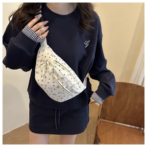 Détail du sac de poitrine en velours blanc avec nœuds marrons et sangle ajustable