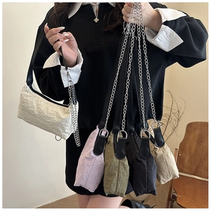 Detail of minimalist textured shoulder bags in multiple colors with chain straps