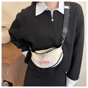 Detail of cream crescent bag featuring pink FANYISSA embroidery and black nylon strap