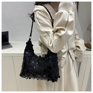 Detail of black dumpling shoulder bag with shimmering sequins and slender strap
