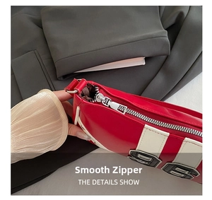 Detailed close-up of smooth silver metal zipper on a red leather Boston shoulder bag