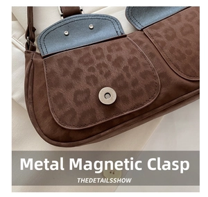 Detailed view of the magnetic snap closure on a brown leopard print suede handbag