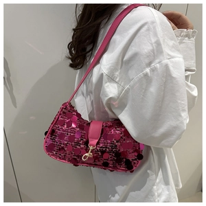 Détail du sac à bandoulière rose à paillettes avec fermoir doré sur chemise blanche