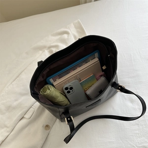 Large black tote bag showing spacious interior with tablet, books, and daily essentials