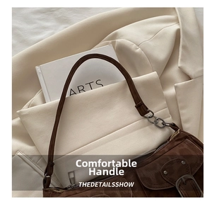 Close-up of coffee brown suede baguette bag with vintage silver metal hardware details