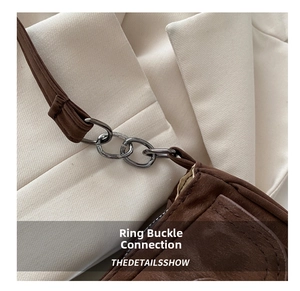 Detail of brown vintage baguette bag showing high-quality metal buckle and strap connection