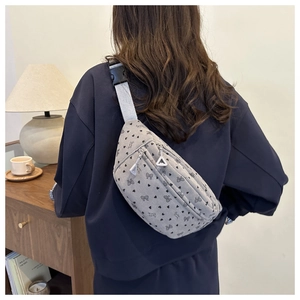 Vue détaillée d'un sac bandoulière en velours côtelé gris clair à motifs nœuds