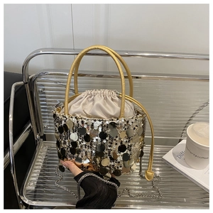 Detail of sequined bucket bag with gold handle, chain strap and drawstring satin lining