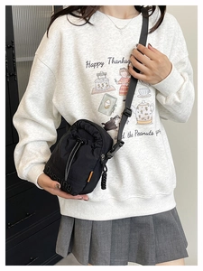Détail du sac bandoulière noir avec sangle réglable et logo de la marque Duoning
