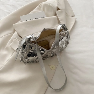 Silver sequin shoulder bag with adjustable strap shown with wallet on a white blazer