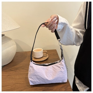 Detail of lavender nylon shoulder bag with silver chain handle and minimalist design
