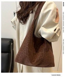 Detail shot of leopard print suede tote bag with wide shoulder strap on model