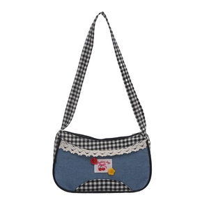 Blue denim underarm bag with plaid trim, lace detail and cherry patch on white background