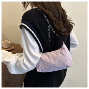 Detail of lavender lilac shoulder bag featuring a silver metal chain strap and crinkled texture