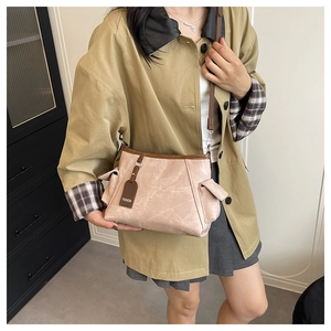 Dettaglio borsa in pelle PU beige a pieghe con etichetta marrone e gancio argento