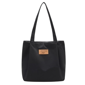 Black canvas tote bag with a leather logo patch, ideal for daily commute and students