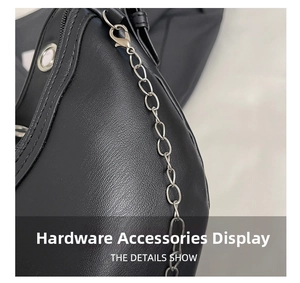 Detailed macro view of silver metal chain and lobster clasp on black lychee leather bag