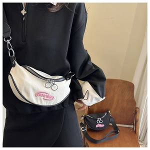 Detail of crescent shoulder bags in black and white with TANYISSA embroidery and zip